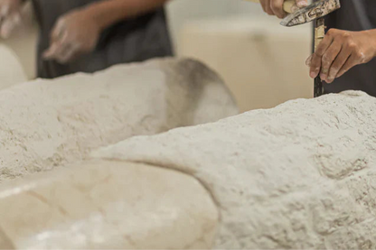Close-up of hands working with dough on a floured surface.