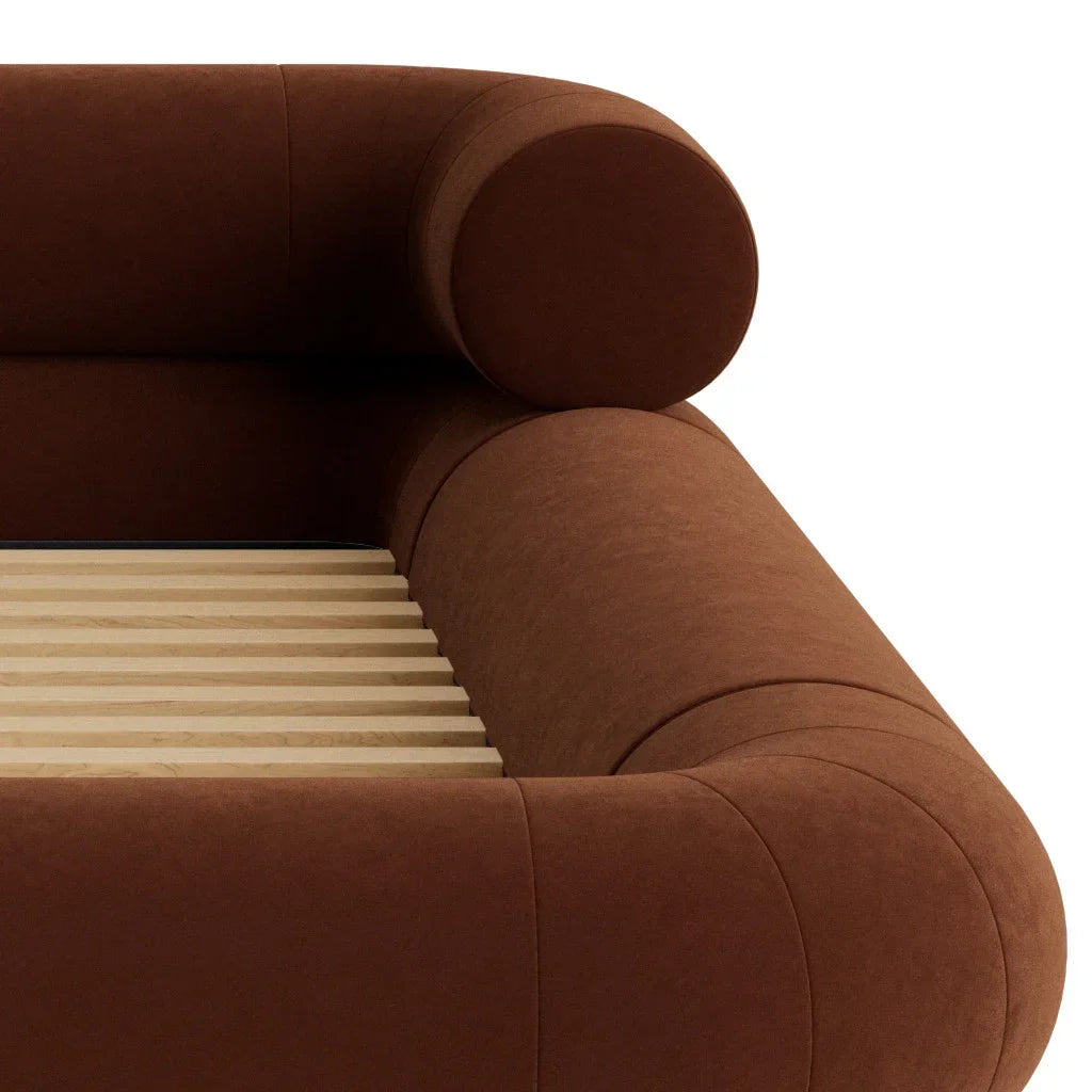 Close-up of VELAR Sculptural Bed Frame in chocolate brown showing cylindrical headboard bolster and padded corner detail